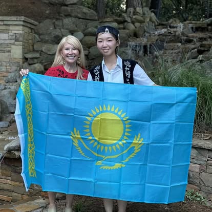 Two Kectil participants smiling together with a Kazakhstan flag.