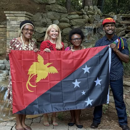 Kectil participants smiling together with a Papua New Guinea flag.