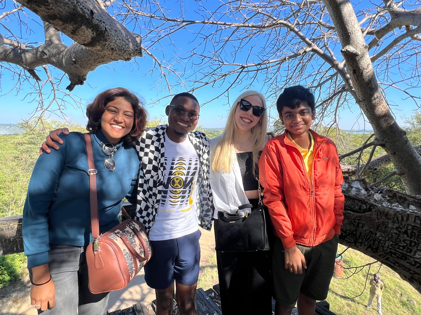Four Kectil participants gathered outdoors under a tree.