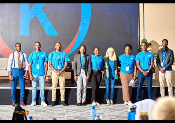 Kectil colleagues on stage in front of the program mark.